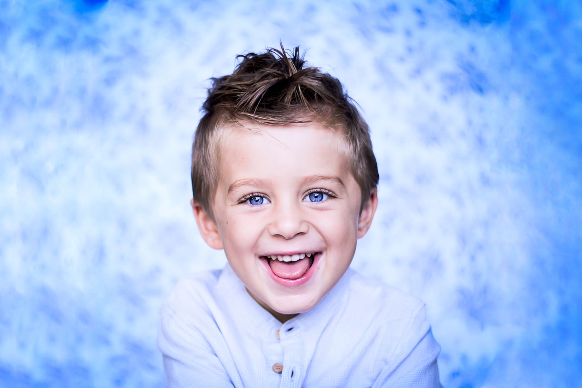Smiling child portrait in soft blue studio light