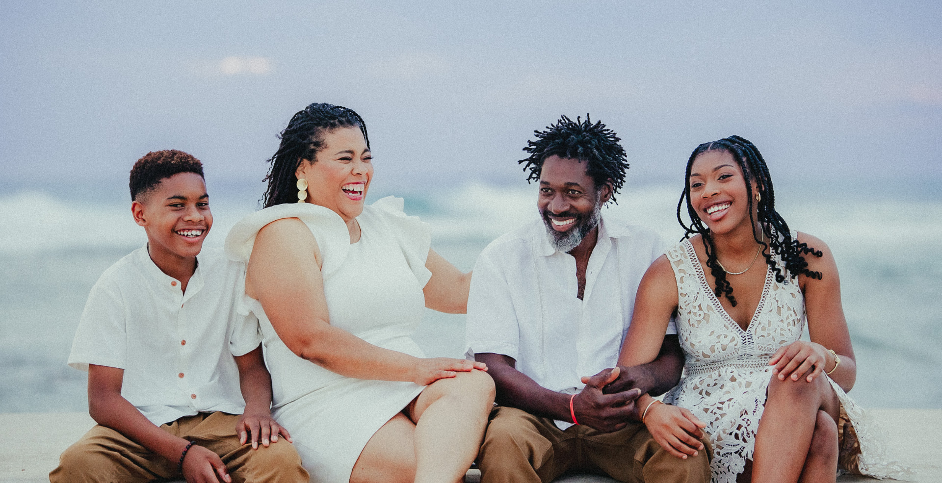 Family laughing together on a Grand Cayman beach at dusk