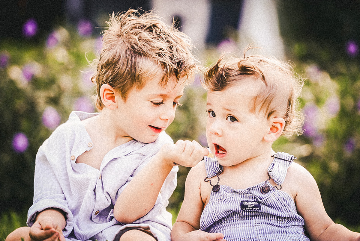 Two young brothers sharing a playful moment outdoors